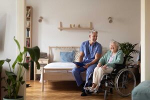 Adult daughter holds elderly woman’s hand in a cozy living room, both expressing concern and comfort.